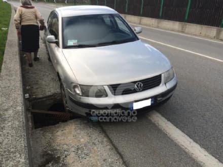 CUORGNE' - Cede il tombino e l'auto s'incastra - FOTO