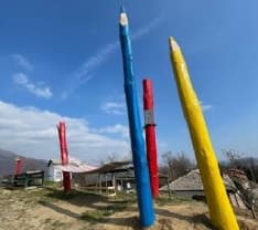 CUORGNE' - Due maxi matite gialloblu accanto all'amaca sul mondo per mandare un grande messaggio di pace